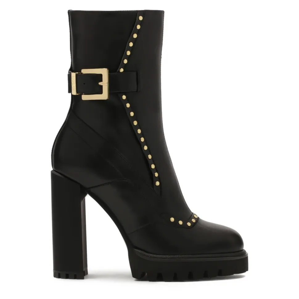 Botas negras con remaches redondos dorados.Este producto tallaje pequeño.