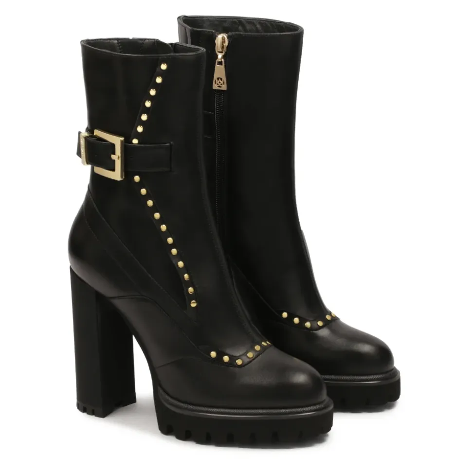 Botas negras con remaches redondos dorados.Este producto tallaje pequeño.