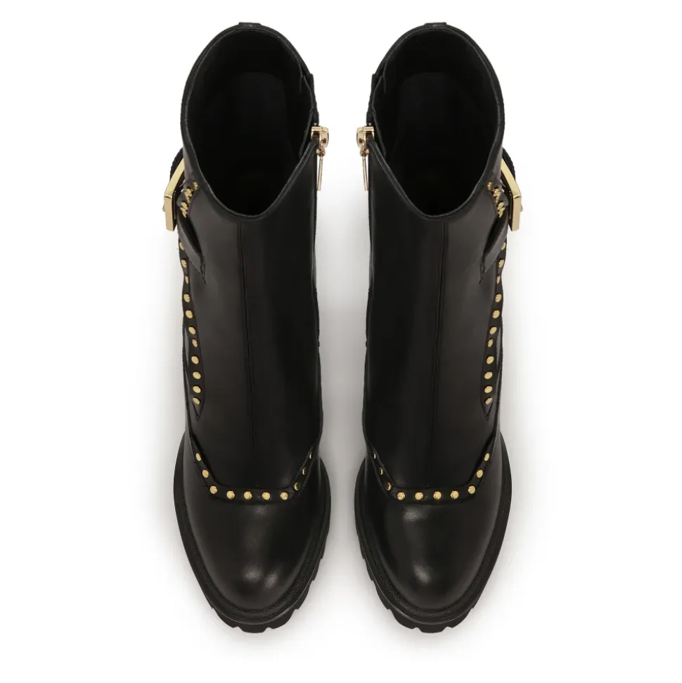 Botas negras con remaches redondos dorados.Este producto tallaje pequeño.